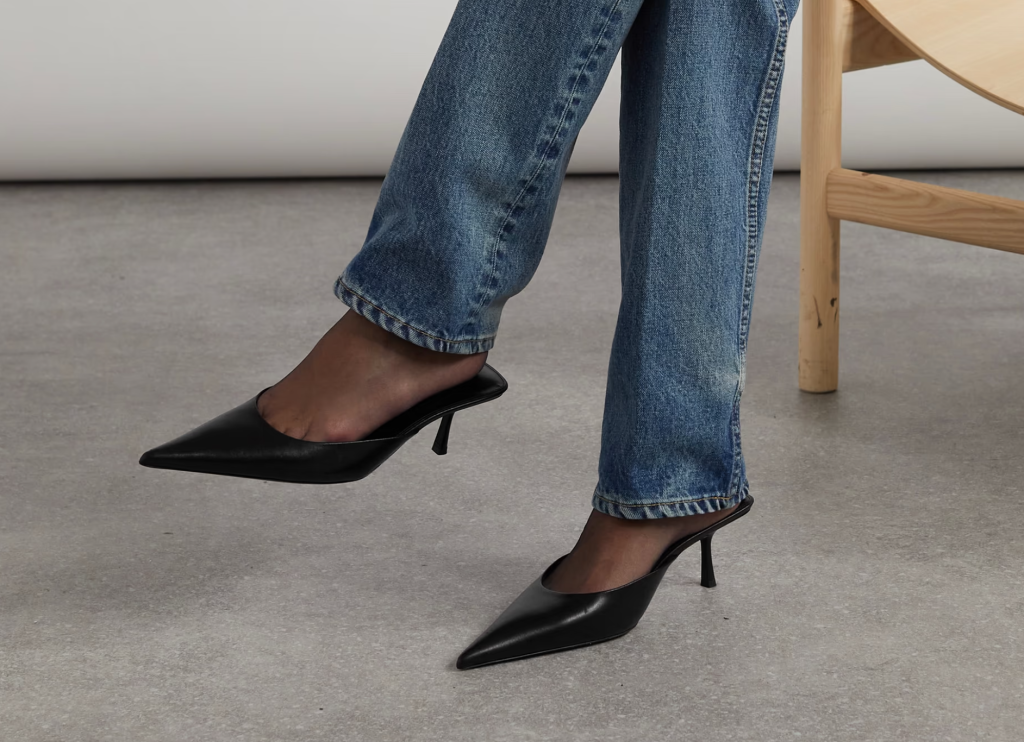 A pair of classic black kitten-heel mules featuring a sleek design with pointed toes and low heels, perfect for both casual and formal occasions.